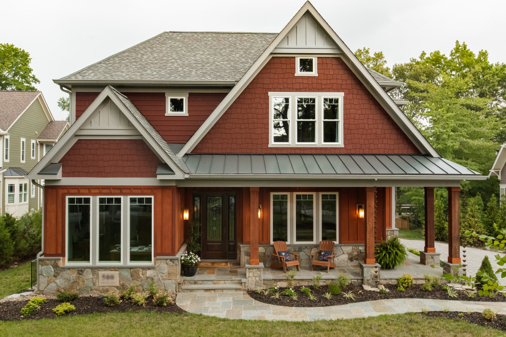 Réalisation d'une grande façade de maison rouge champêtre à un étage avec un revêtement mixte et un toit en shingle.