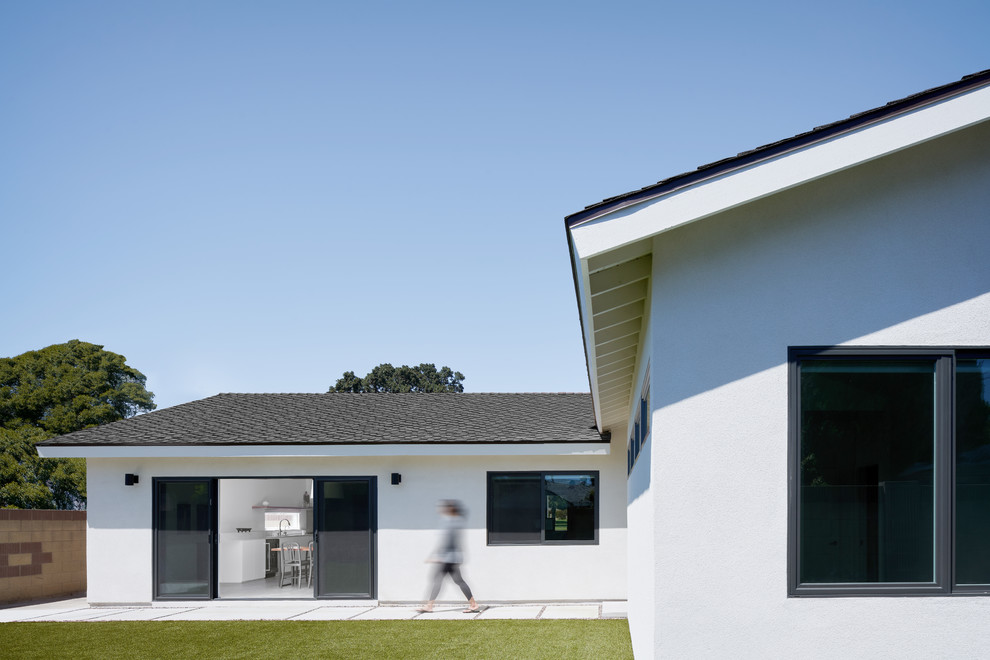Idées déco pour une façade de maison blanche moderne en stuc de plain-pied avec un toit à deux pans et un toit en shingle.