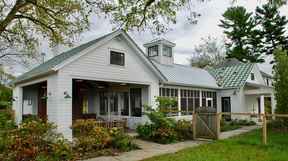 Example of a cottage white one-story concrete fiberboard exterior home design in Chicago with a metal roof