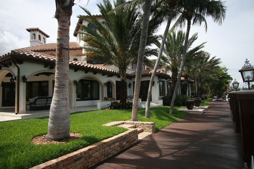 マイアミにある巨大な地中海スタイルのおしゃれな家の外観 (アドベサイディング) の写真