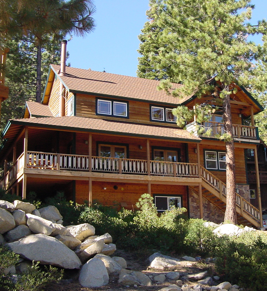 Exemple d'une très grande façade de maison marron montagne en bois à deux étages et plus avec un toit à deux pans et un toit en tuile.