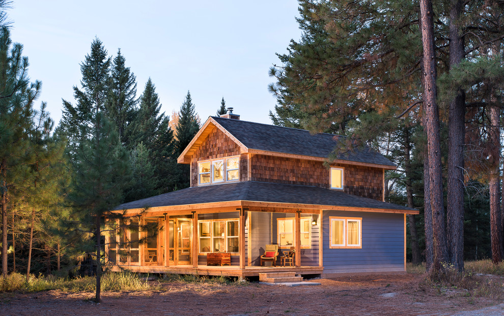 Cette image montre une petite façade de maison bleue chalet à un étage avec un revêtement mixte et un toit à deux pans.
