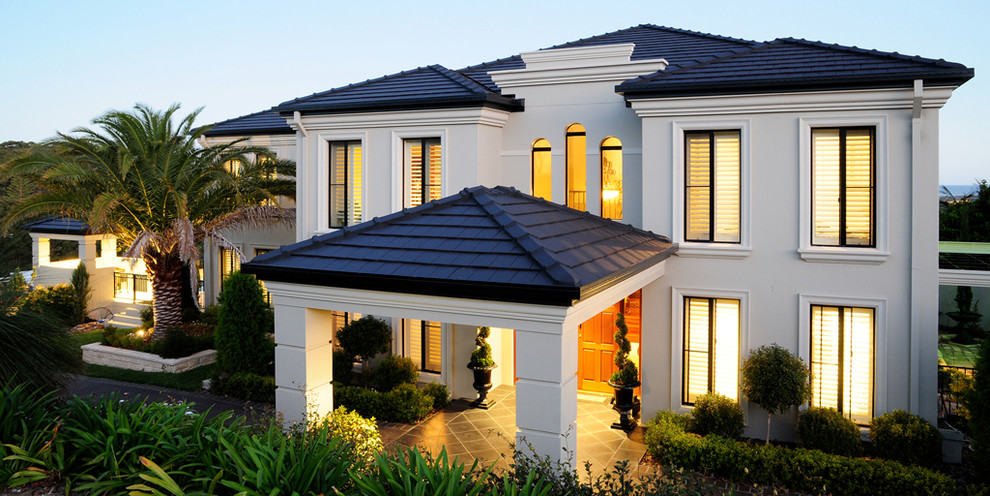 This is an example of a large and beige traditional two floor detached house in Brisbane with a hip roof and a tiled roof.