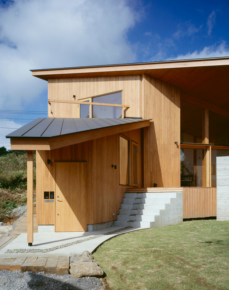Стильный дизайн: двухэтажный, деревянный, коричневый частный загородный дом среднего размера в современном стиле с односкатной крышей и металлической крышей - последний тренд