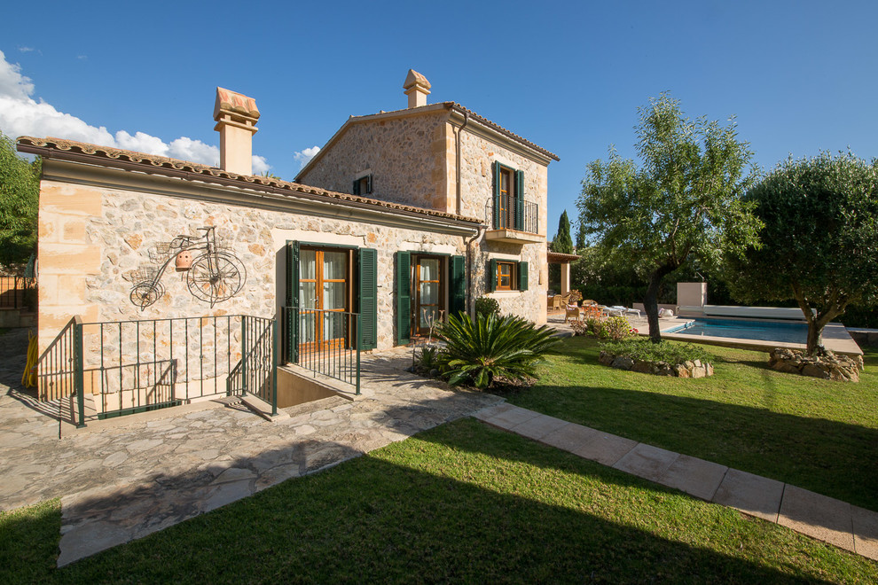 Idee per la facciata di una casa beige mediterranea a due piani di medie dimensioni con rivestimento in pietra