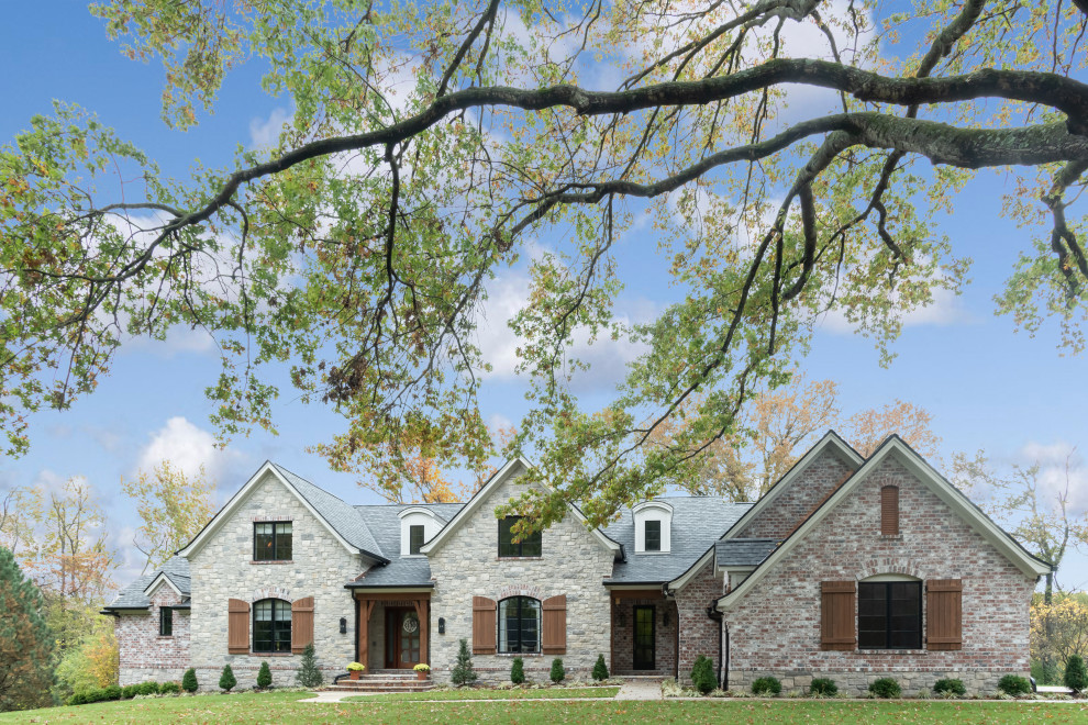Ejemplo de fachada de casa gris grande de dos plantas con tejado de teja de madera y revestimientos combinados
