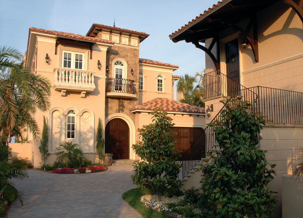 Ejemplo de fachada de casa beige clásica grande de dos plantas con revestimientos combinados, tejado a cuatro aguas y tejado de teja de barro