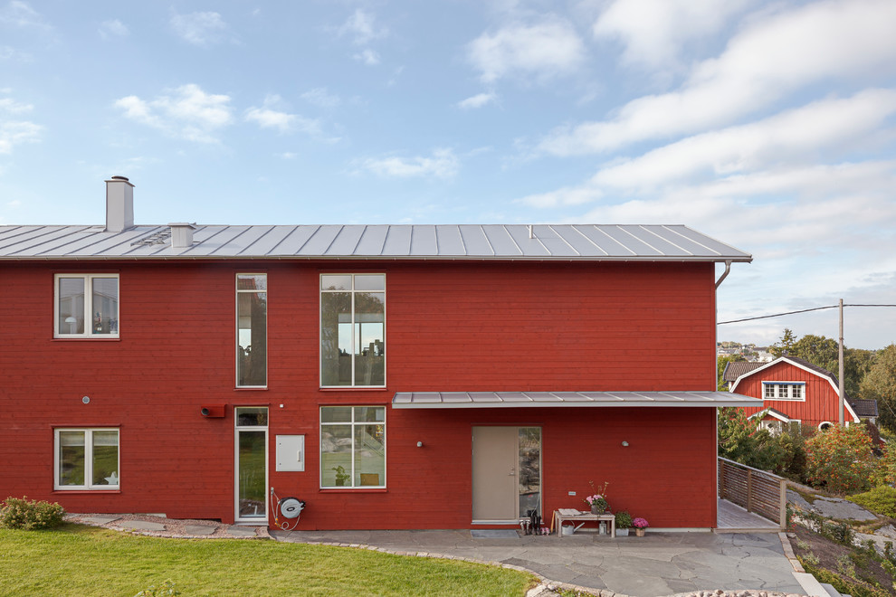 Idées déco pour une grande façade de grange rénovée rouge scandinave en bois à un étage avec un toit en appentis.