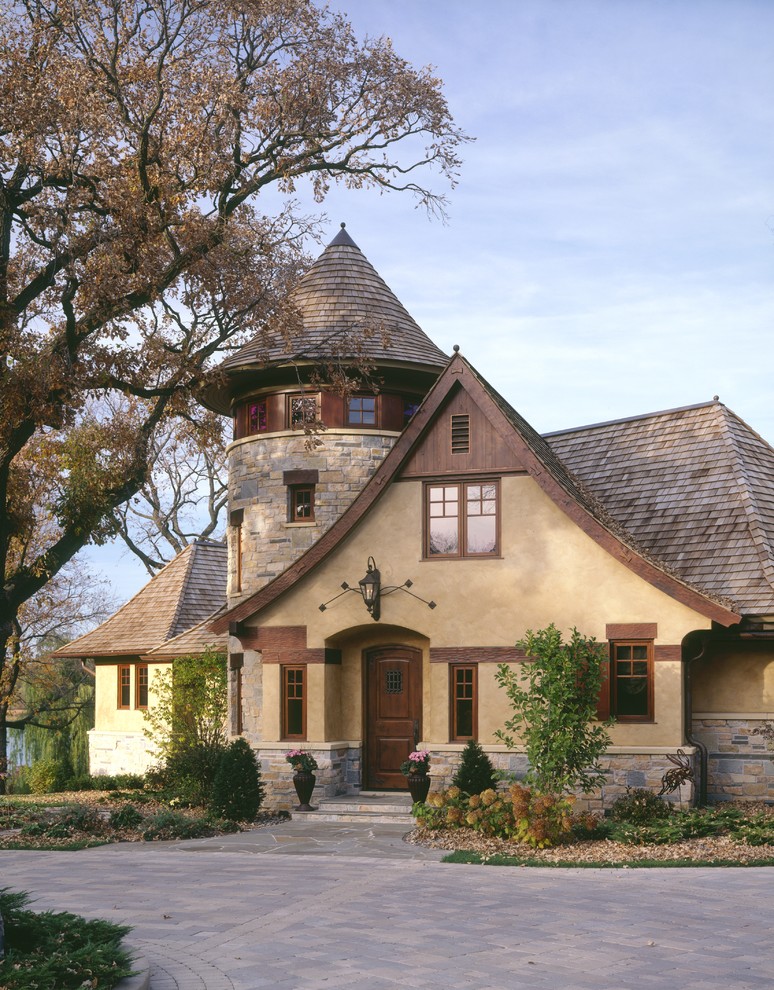 Modelo de fachada beige clásica con revestimientos combinados y tejado a dos aguas