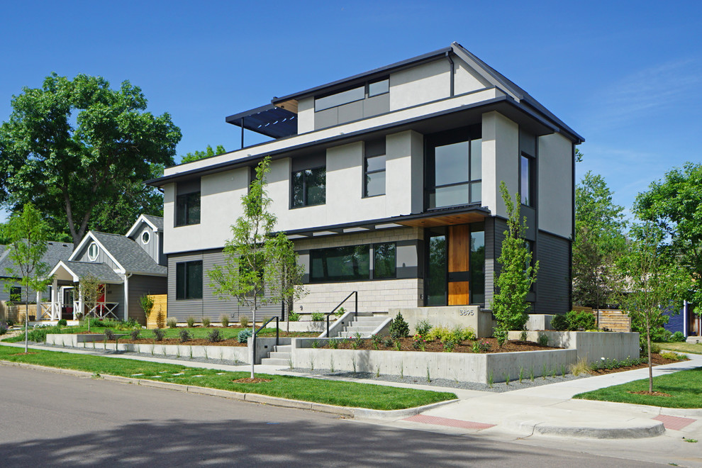 Ejemplo de fachada de casa multicolor moderna grande de tres plantas con revestimientos combinados, tejado plano y tejado de metal