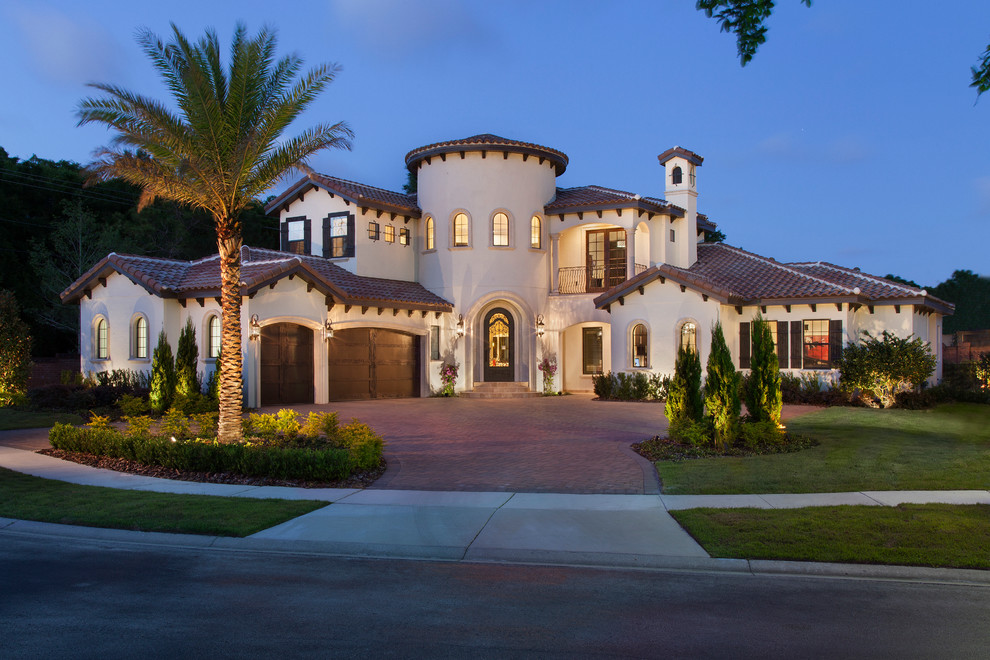 This is an example of a large and white mediterranean two floor render house exterior in Orlando.