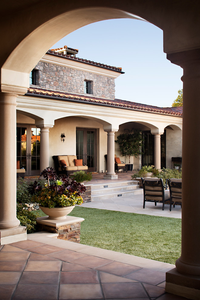 Inspiration for a large mediterranean beige one-story stucco exterior home remodel in San Diego with a hip roof