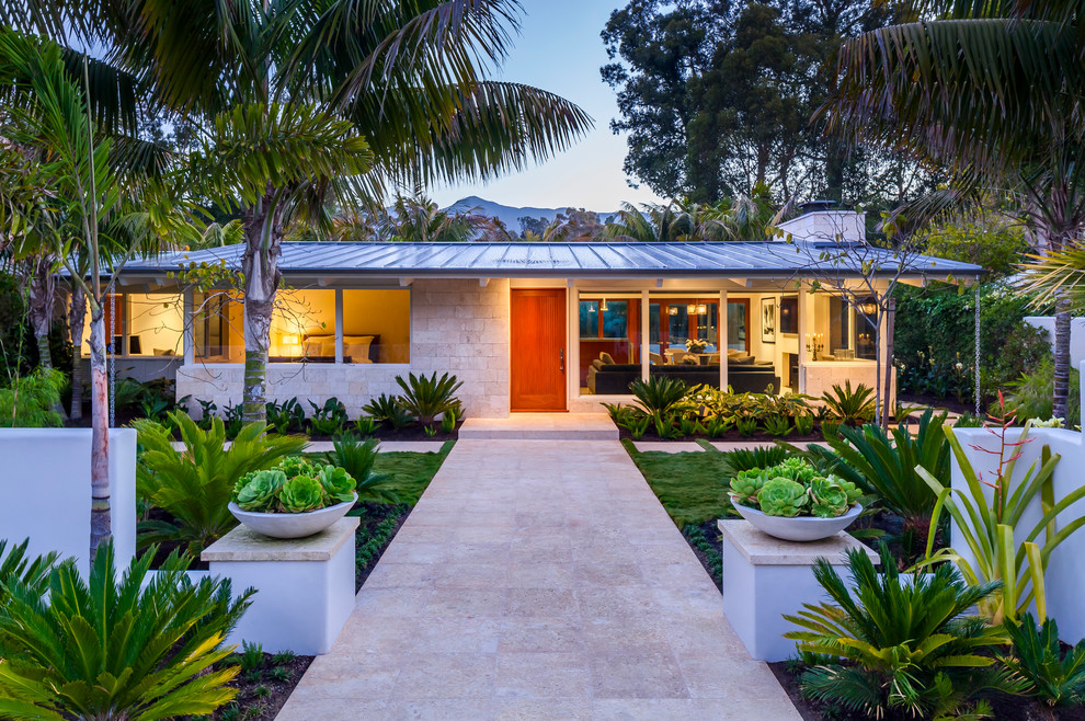 Photo of a small and white midcentury bungalow house exterior in Santa Barbara with stone cladding and a metal roof.