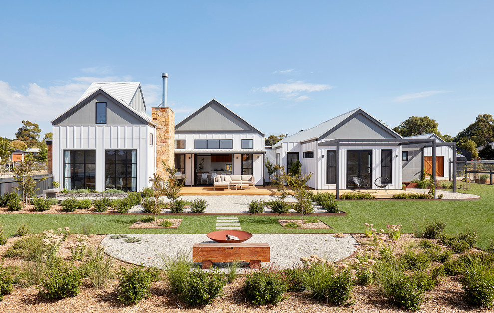 Mittelgroßes, Einstöckiges Landhausstil Einfamilienhaus mit weißer Fassadenfarbe, Satteldach und Blechdach in Melbourne