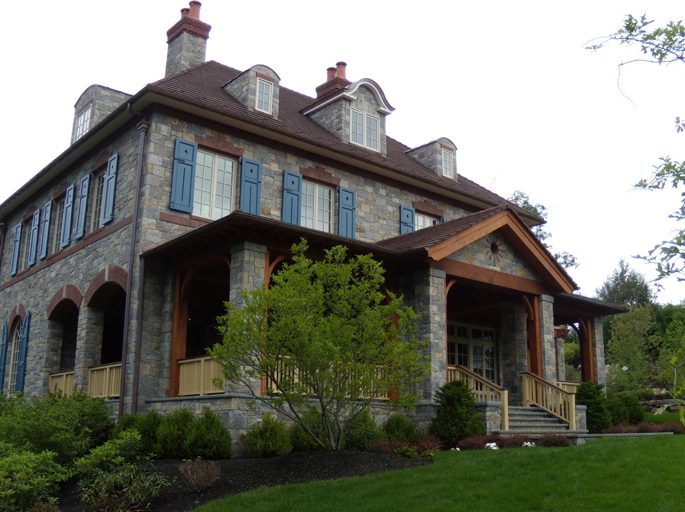 Стильный дизайн: дом в классическом стиле с облицовкой из камня и вальмовой крышей - последний тренд