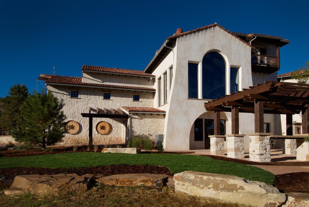 Стильный дизайн: большой, двухэтажный, белый дом в средиземноморском стиле с облицовкой из цементной штукатурки - последний тренд