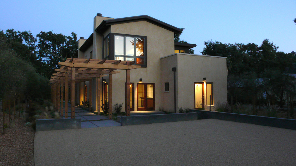 Immagine della facciata di una casa beige contemporanea a due piani di medie dimensioni con rivestimento in stucco e tetto a capanna
