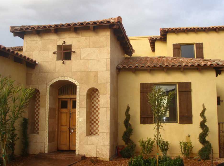 Cette photo montre une façade de maison jaune méditerranéenne de taille moyenne et à un étage avec un revêtement mixte et un toit à quatre pans.