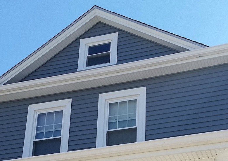 Medium sized and blue traditional two floor house exterior in Providence with vinyl cladding and a hip roof.