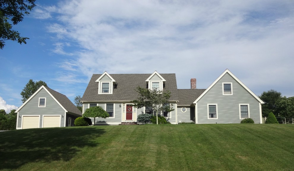 Exemple d'une façade de maison grise chic de taille moyenne et à un étage avec un revêtement en vinyle et un toit à deux pans.