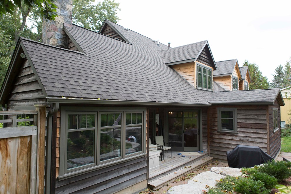 Large and gey rustic two floor house exterior in Toronto with wood cladding and a pitched roof.