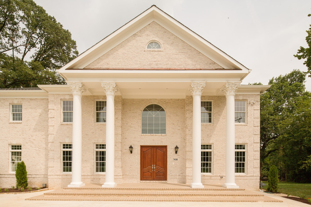 Foto della facciata di una casa ampia beige classica con rivestimento in mattoni