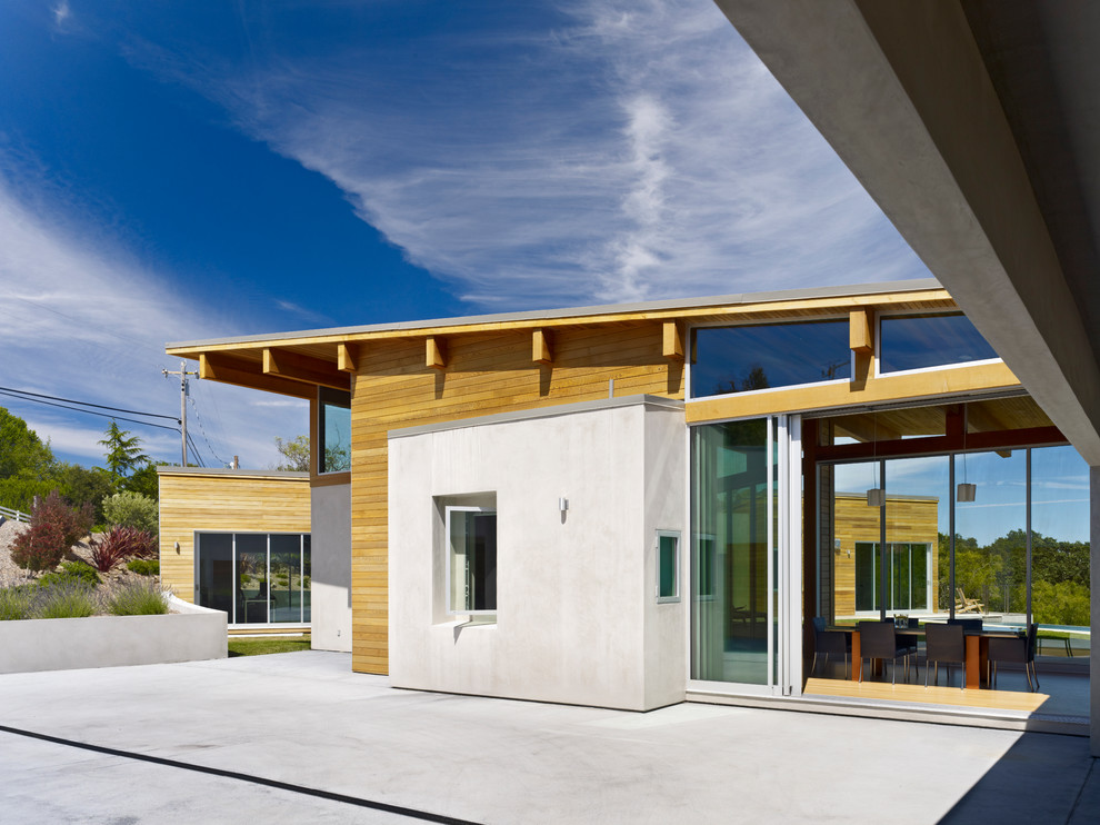 Idée de décoration pour une grande façade de maison blanche design en bois de plain-pied avec un toit en appentis.
