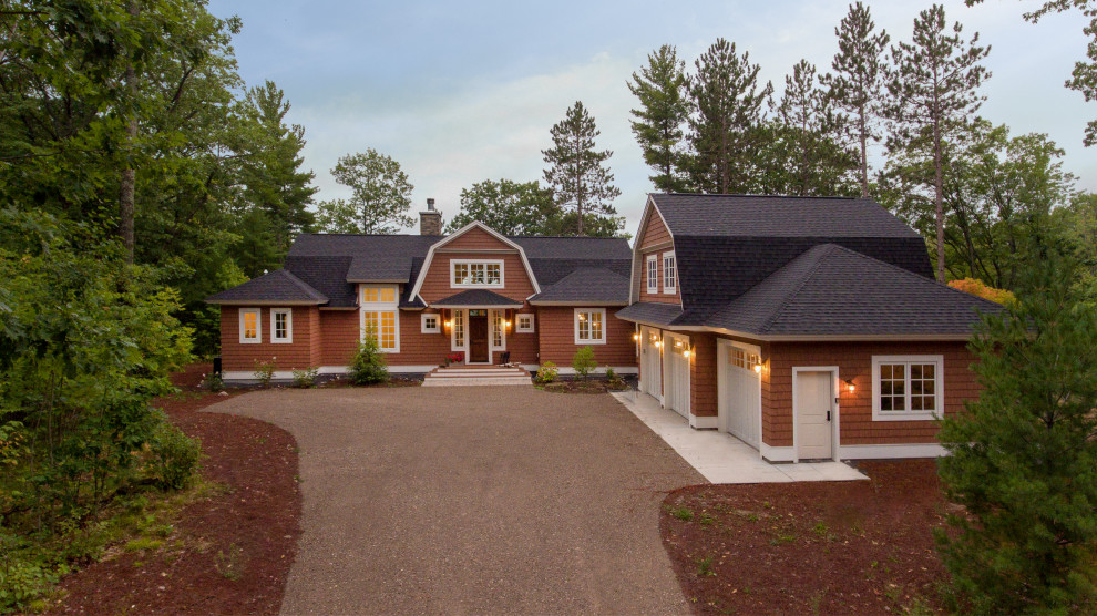 Large elegant brown two-story vinyl house exterior photo in Other with a gambrel roof and a shingle roof