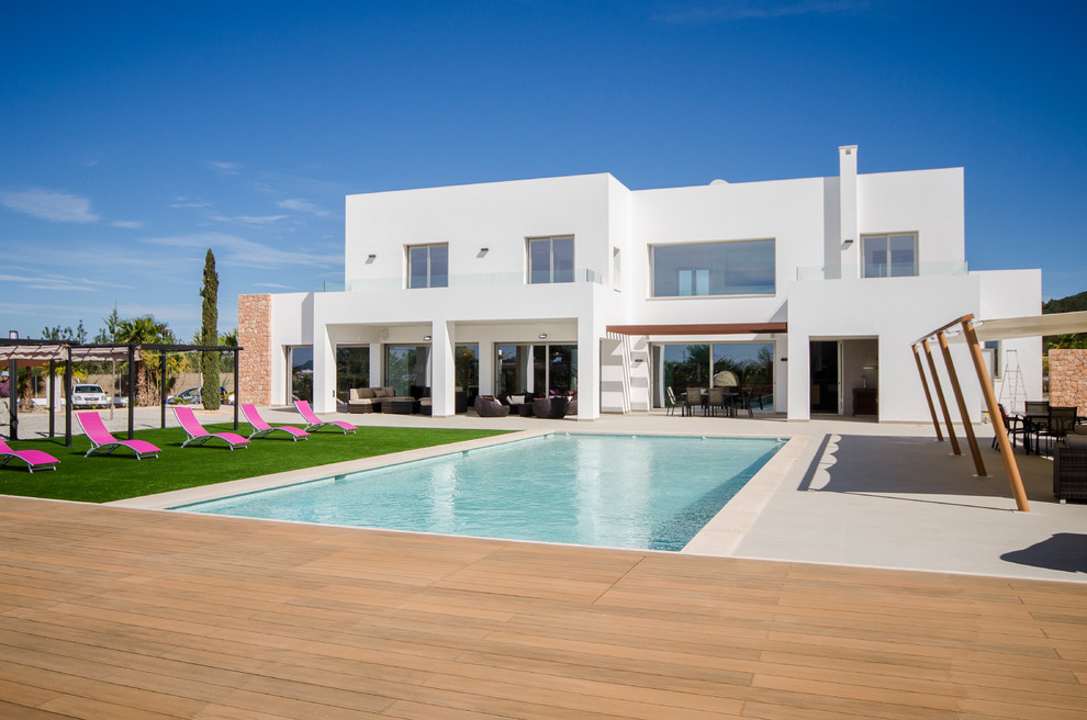 На фото: двухэтажный, белый дом среднего размера в средиземноморском стиле с облицовкой из ЦСП и плоской крышей с