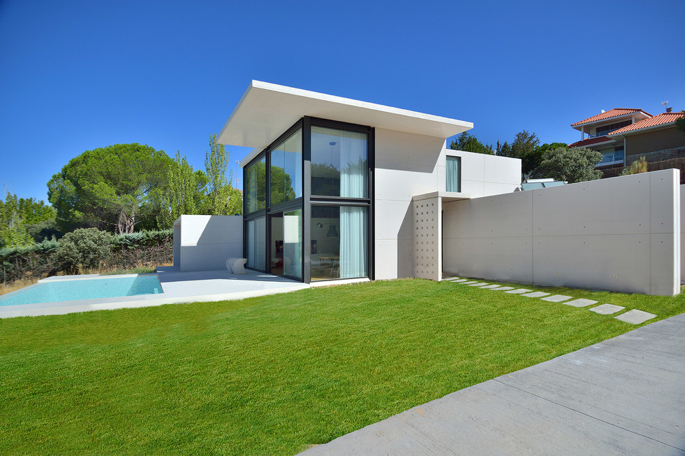 Ejemplo de fachada blanca minimalista grande de dos plantas con tejado plano y revestimiento de hormigón