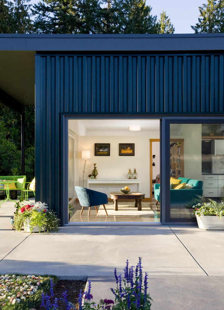 Modern inredning av ett blått hus, med allt i ett plan, metallfasad och platt tak