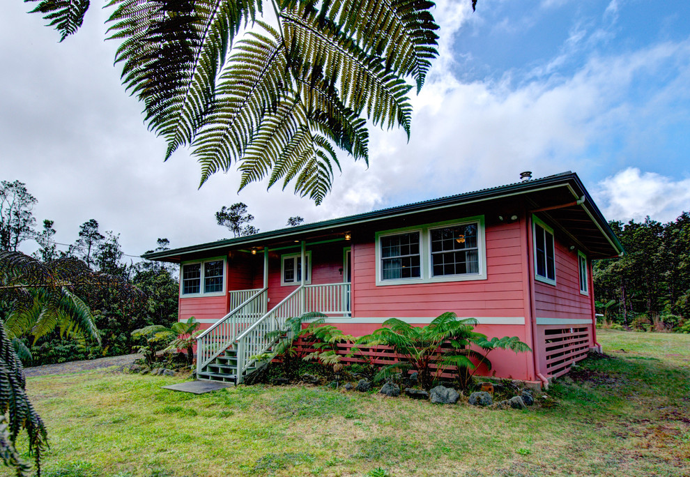 Inspiration for a world-inspired bungalow house exterior in Hawaii with a pink house.