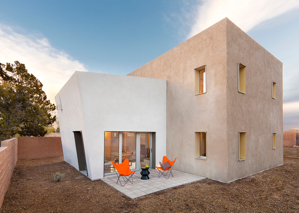 Large and beige contemporary two floor render detached house in Albuquerque with a flat roof.