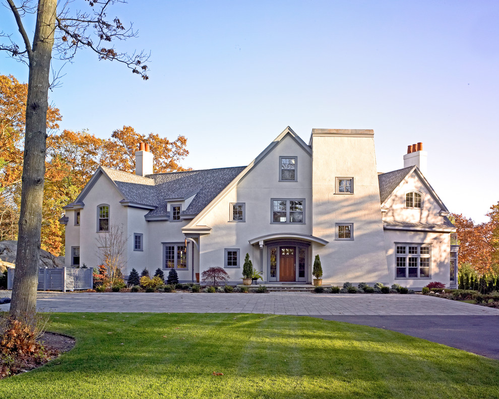 Inspiration for a large coastal beige three-story stucco gable roof remodel in Boston