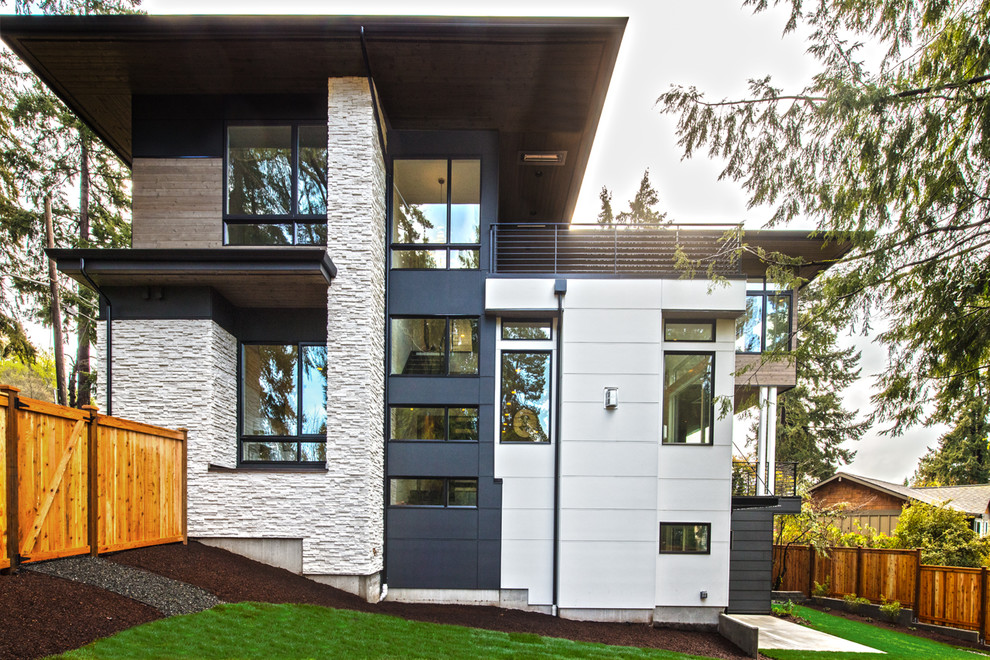 Modelo de fachada de casa multicolor clásica renovada grande de dos plantas con revestimientos combinados, tejado plano y tejado de teja de madera