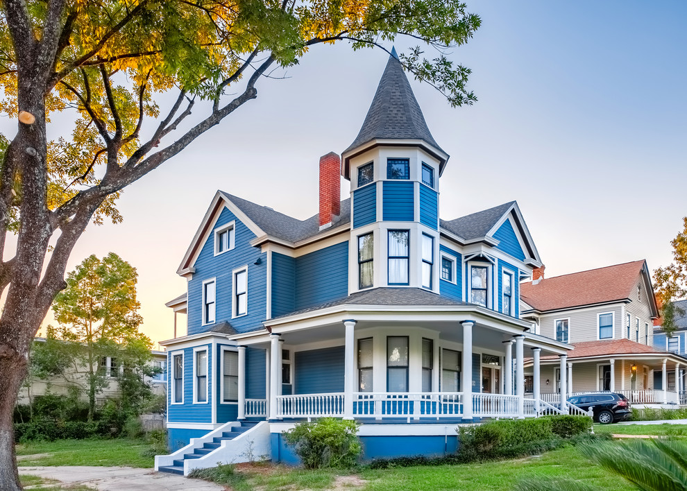 Diseño de fachada de casa azul clásica extra grande de tres plantas con revestimiento de madera, tejado a dos aguas y tejado de teja de madera