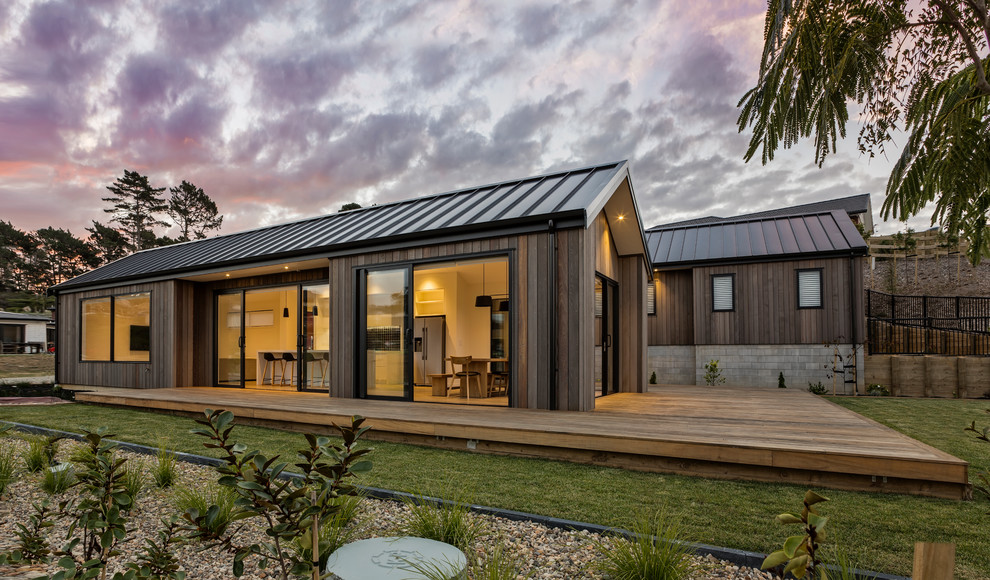 Diseño de fachada de casa marrón actual de tamaño medio de una planta con revestimiento de madera, tejado a dos aguas y tejado de metal