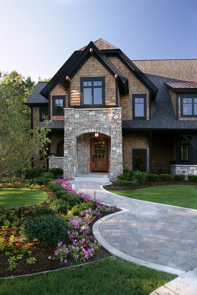 Пример оригинального дизайна: большой, трехэтажный, коричневый дом в классическом стиле с облицовкой из ЦСП и полувальмовой крышей