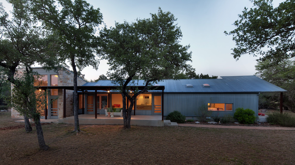 Industrial house exterior in Austin with metal cladding and a lean-to roof.