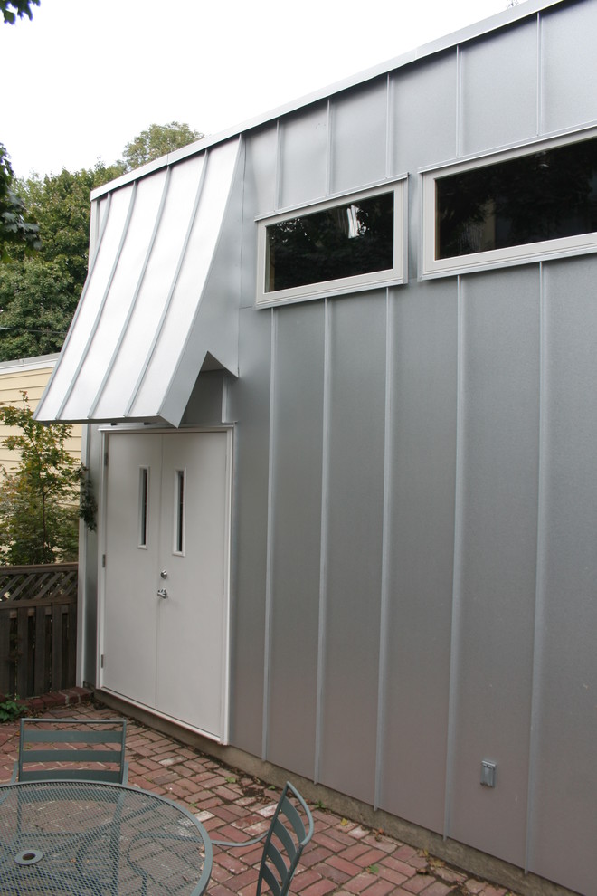 Идея дизайна: трехэтажный, серый дом в стиле модернизм с облицовкой из металла и плоской крышей