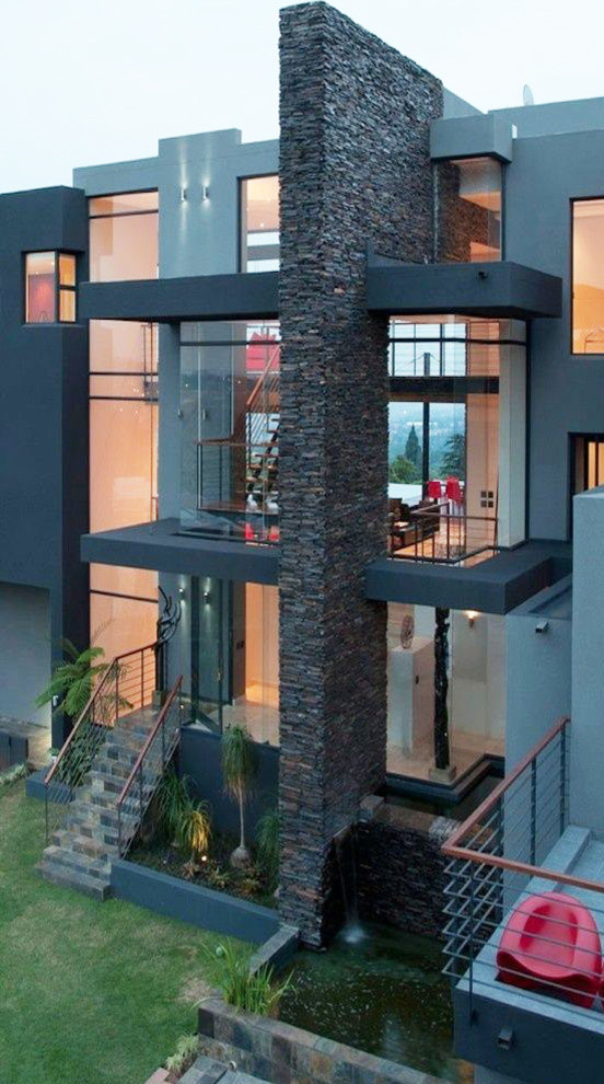 На фото: серый дом в стиле модернизм с облицовкой из камня с