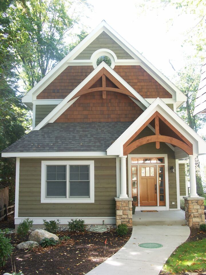 Example of an arts and crafts multicolored two-story wood gable roof design in Other