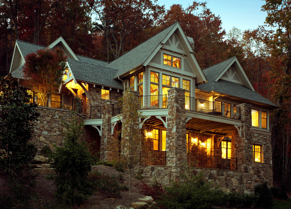Esempio della facciata di una casa beige classica a due piani di medie dimensioni con rivestimento in pietra e tetto a capanna