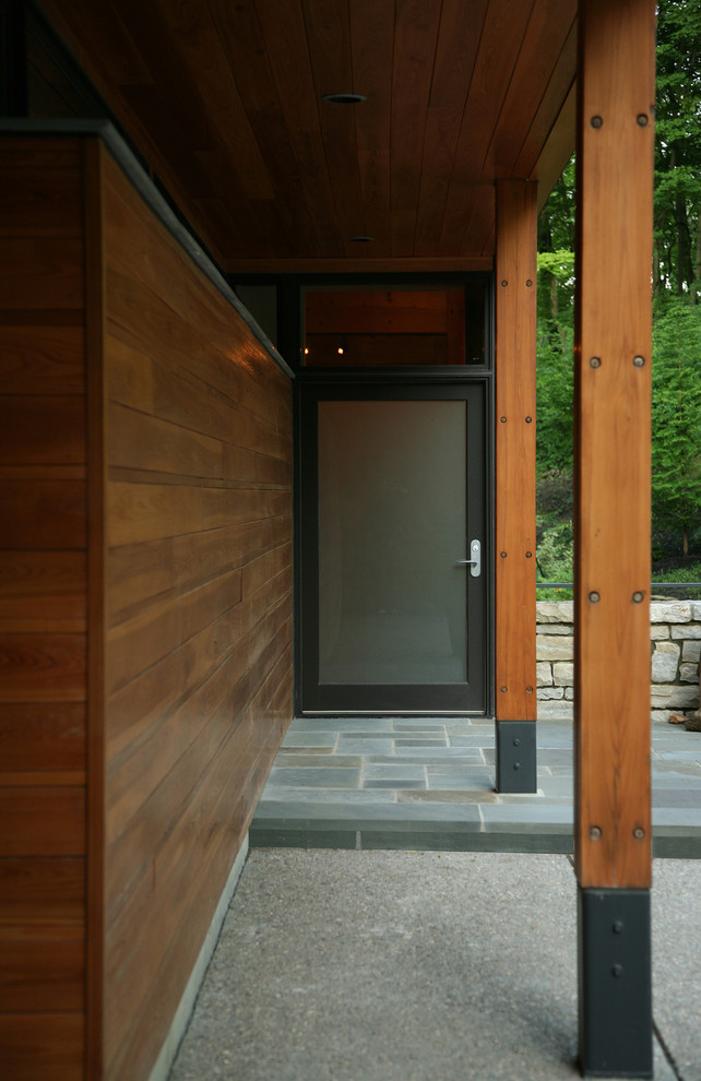 Inspiration pour une grande façade de maison marron design en bois à deux étages et plus avec un toit en appentis et un toit végétal.