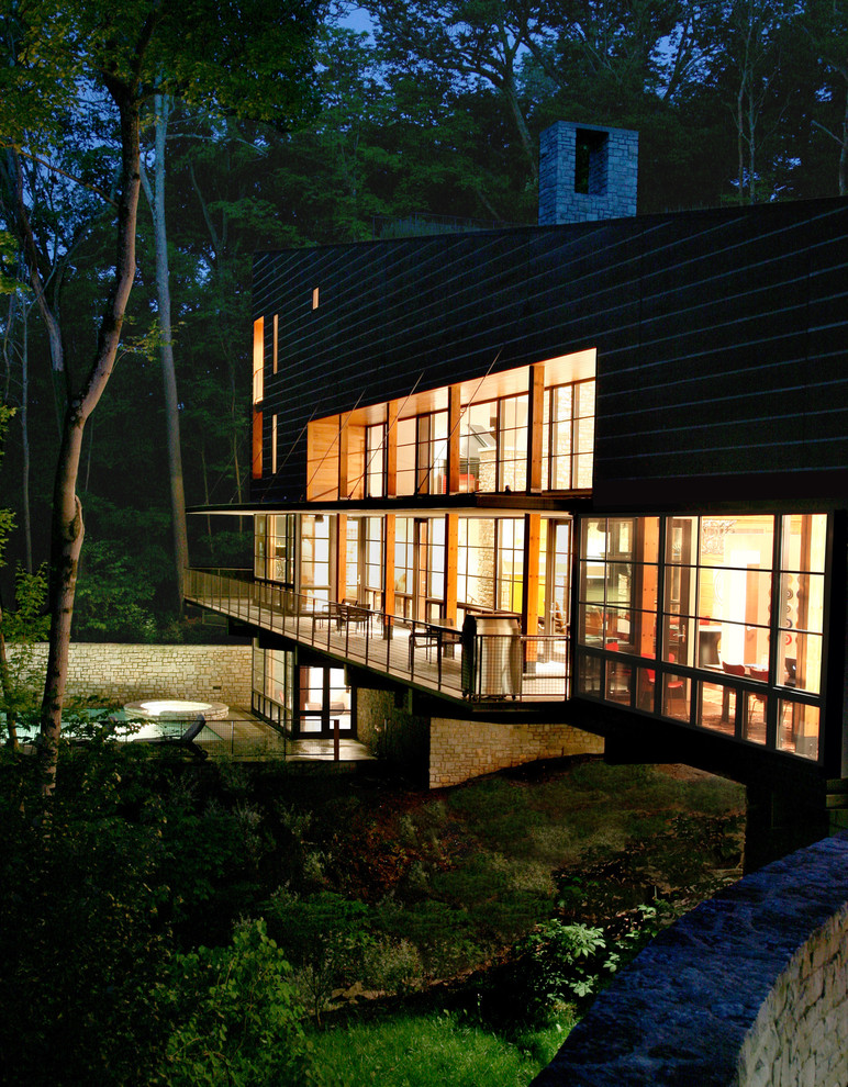 Réalisation d'une grande façade de maison container marron design en bois à deux étages et plus avec un toit en appentis et un toit végétal.