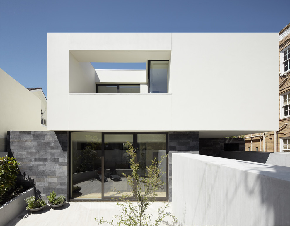 Idée de décoration pour une façade de maison minimaliste de taille moyenne et à un étage avec un toit plat.