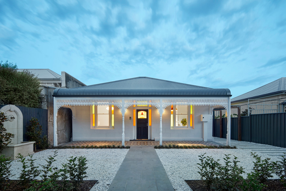 Large elegant white one-story stucco exterior home photo in Melbourne with a hip roof