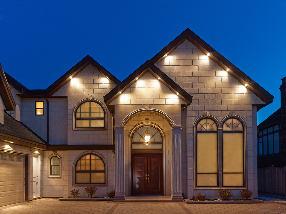 This is an example of a medium sized and beige traditional two floor house exterior in Vancouver.