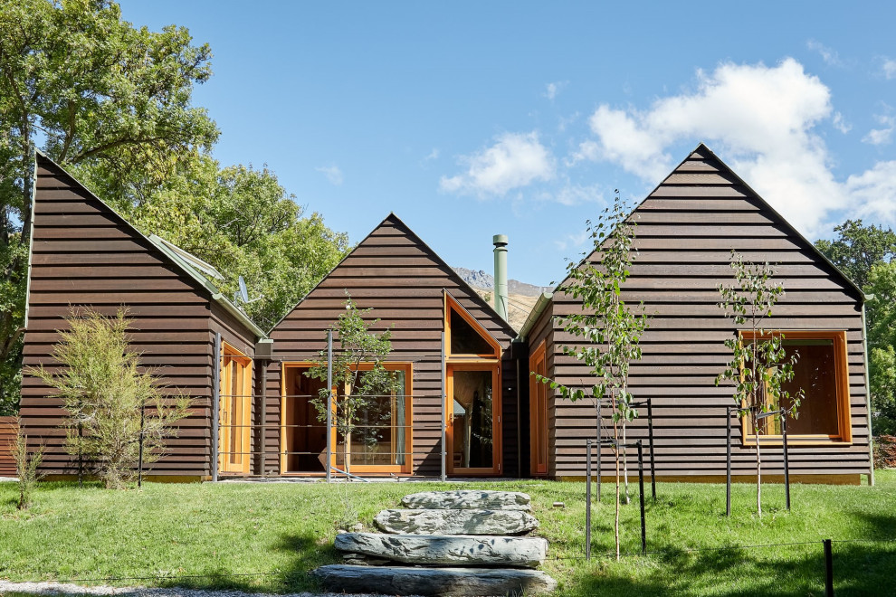 Idee per la villa marrone moderna a un piano di medie dimensioni con rivestimento in legno e tetto a capanna