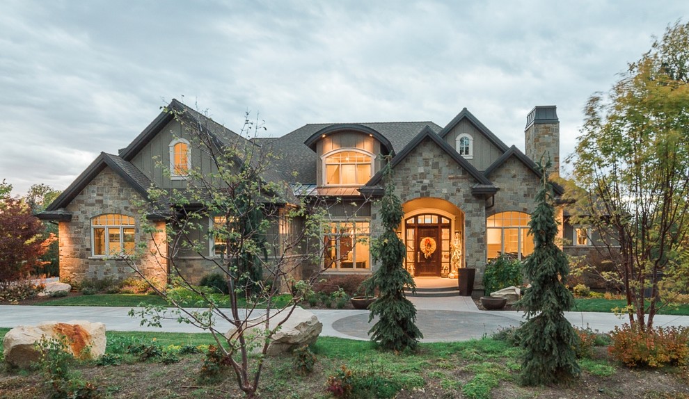 Traditional beige two-story stone exterior home idea in Salt Lake City with a hip roof